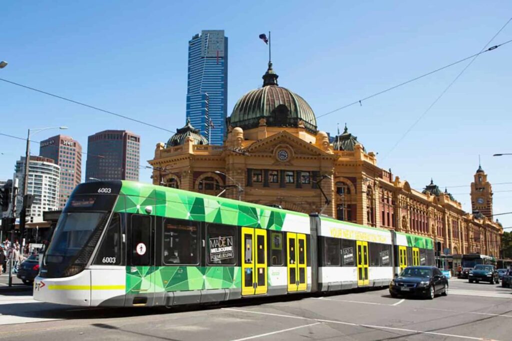 "Vista de um trem moderno circulando pelas paisagens deslumbrantes da Austrália, oferecendo uma forma eficiente e confortável de transporte nas grandes cidades."